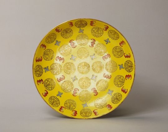 Plate with red bat and gold color group longevity pattern on yellow ground, The Palace Museum